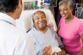 Doctor talking to patient in bed